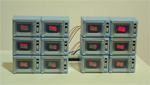 A cluster of electronically modified 80's vintage toy microwaves.