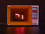 An electronically modified vintage toy microwave.